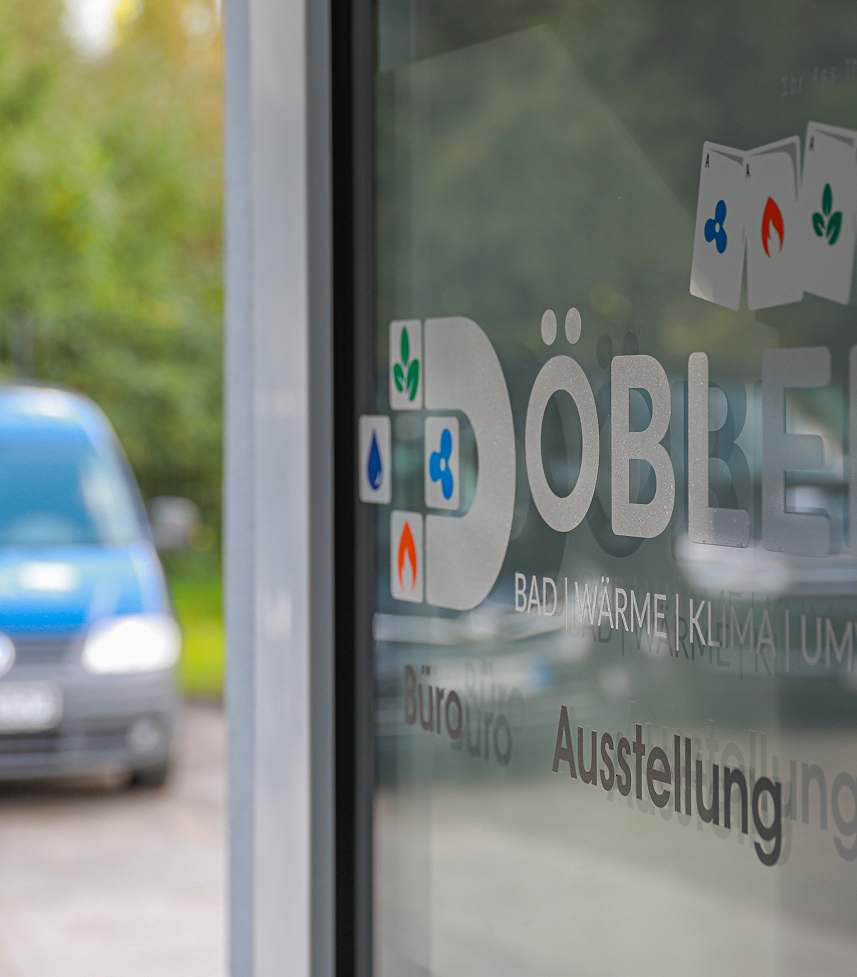 Eine Glastür zeigt den Firmennamen DÖBLER mit Symbolen und deutschen Wörtern wie Büro und Ausstellung. Im Hintergrund ist unscharf ein blauer Lieferwagen zu erkennen, der im Freien geparkt ist. Eine Glastür zeigt den Firmennamen DÖBLER mit Symbolen und deutschen Wörtern wie Büro und Ausstellung. Im Hintergrund ist unscharf ein blauer Lieferwagen zu erkennen, der im Freien geparkt ist.